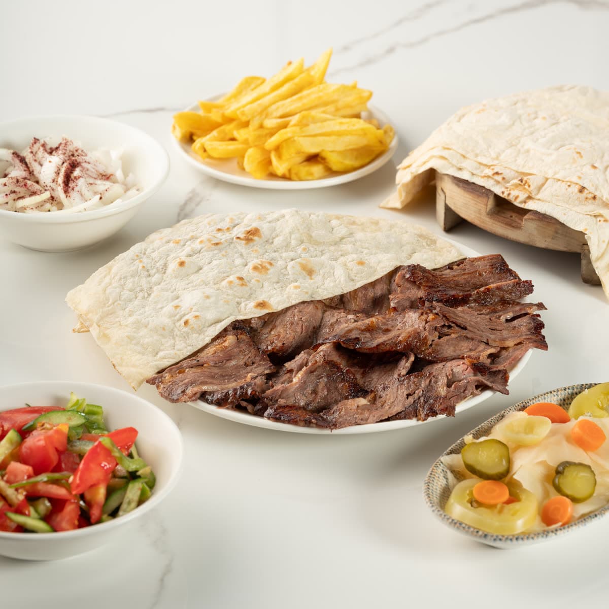 Taze lavaşa sarılmış döner dürüm, yanında patates kızartması ve turşu