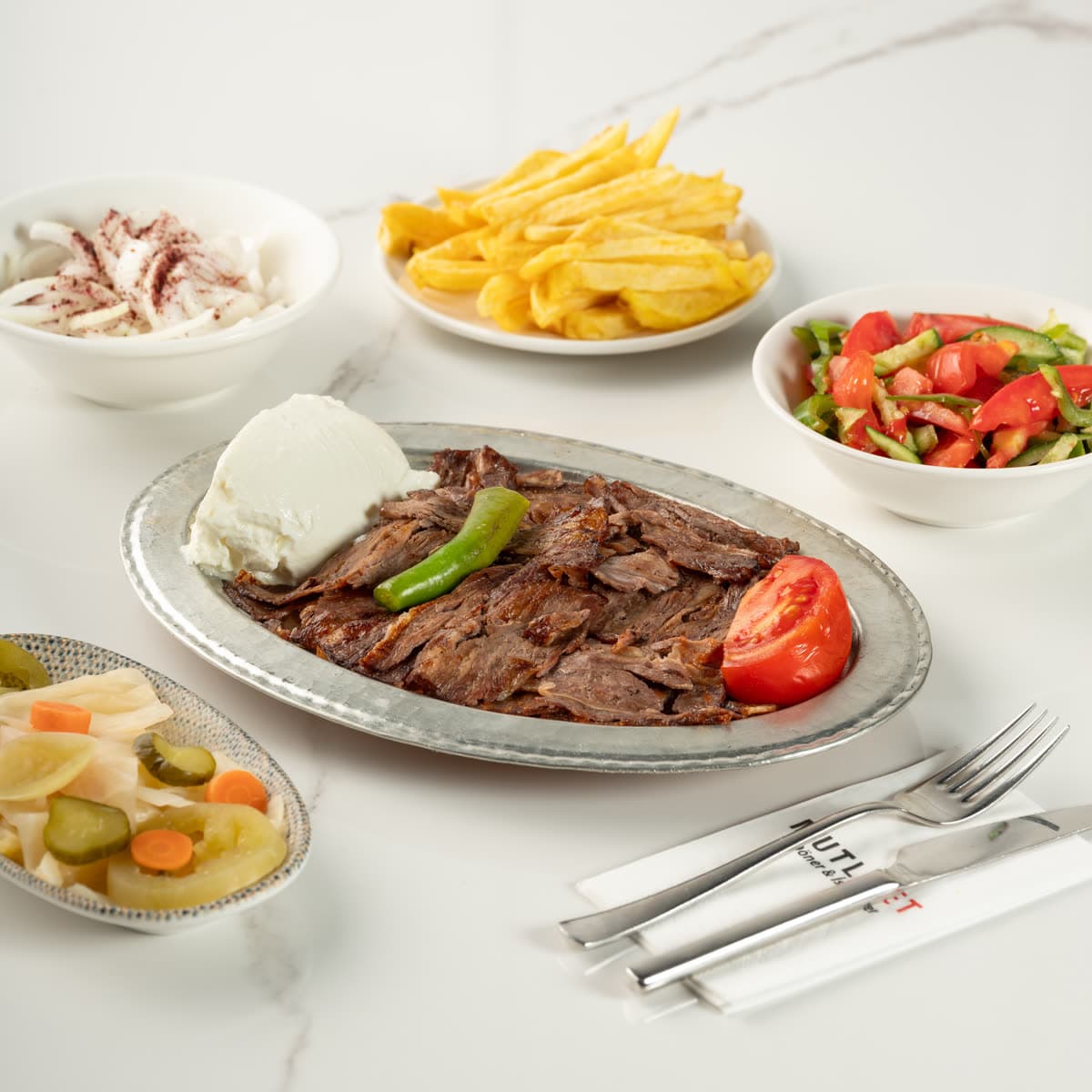Mutlu Et İskender kebap porsiyonu: bakır tepside döner, domates sosu, yoğurt, közlenmiş biber ve domates