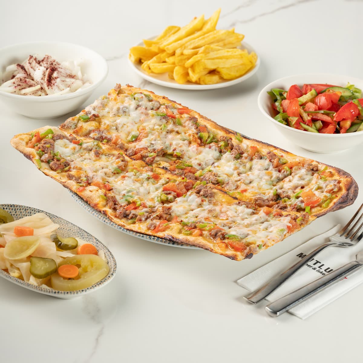 Taş fırında karışık pide: kaşar peyniri, et ve sebzeyle, dilimlenmiş halde