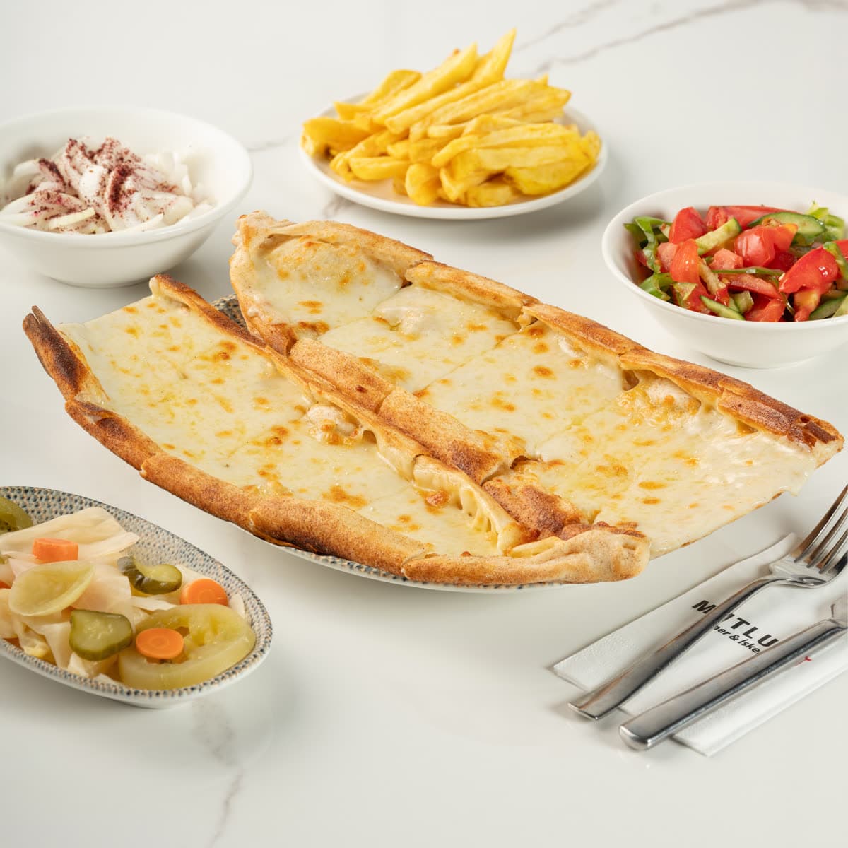 Eritilmiş kaşar peynirli taş fırın pidesi, uzun dilimler hâlinde servis